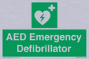 green-background-with-white-text-and-heart-defibrillator-symbol--white-cross-and~